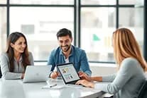 Colleagues talking beside a laptop