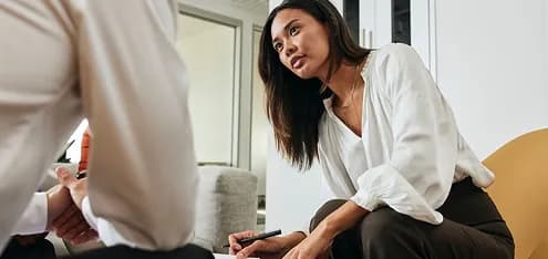 Colleague seated in conversation with a coworker