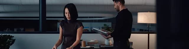 Two colleagues reviewing material in a dimly lit evening office