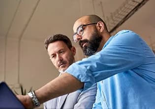 Two analysts reviewing material together on a tablet