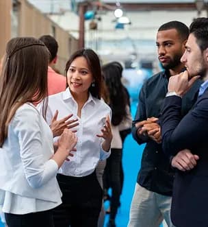 Colleagues in conversation at a busy industry event