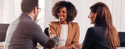 Colleagues smiling in conversation around a meeting table