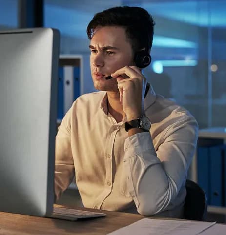 A support agent wearing a headset working at a computer