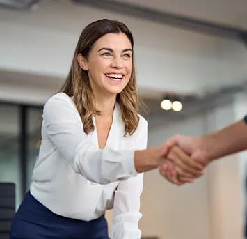 A smiling professional shaking hands with a colleague