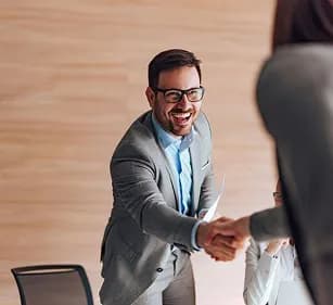 A smiling professional shaking hands with a visitor
