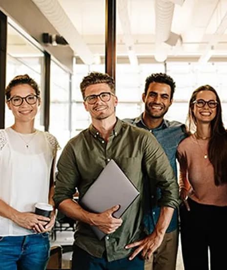 A smiling team standing together in a bright office