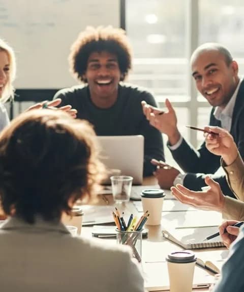 A smiling team in discussion around a meeting table
