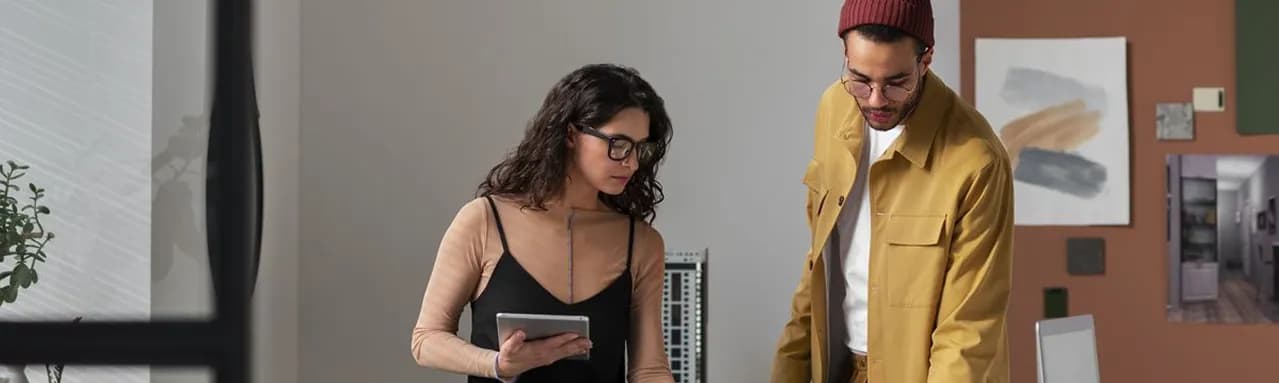 Two colleagues reviewing a tablet together in a studio