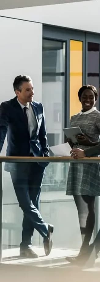 Two colleagues talking while walking through an office atrium