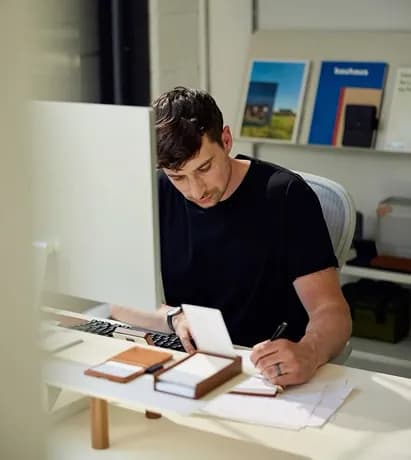 Developer writing notes at a desk