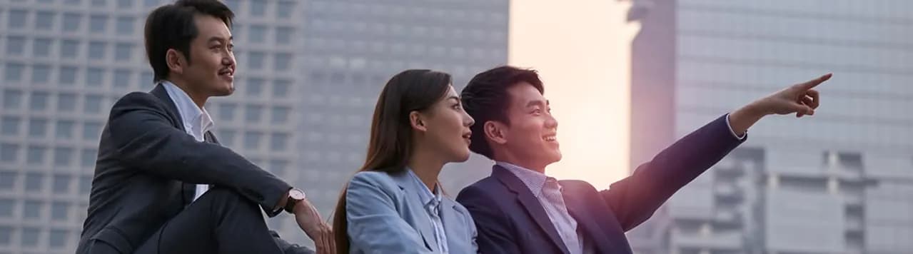 Colleagues sitting outside a building looking toward the skyline