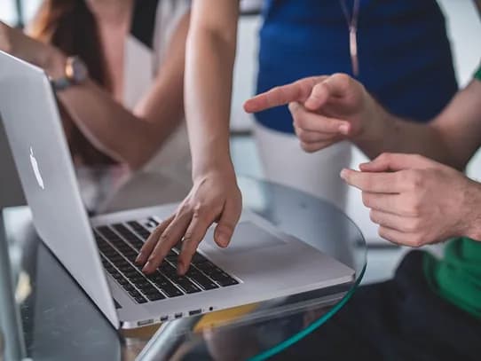 Colleagues pointing at a laptop screen together