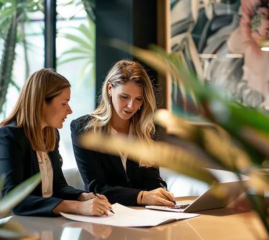 Two colleagues reviewing paperwork together at a table