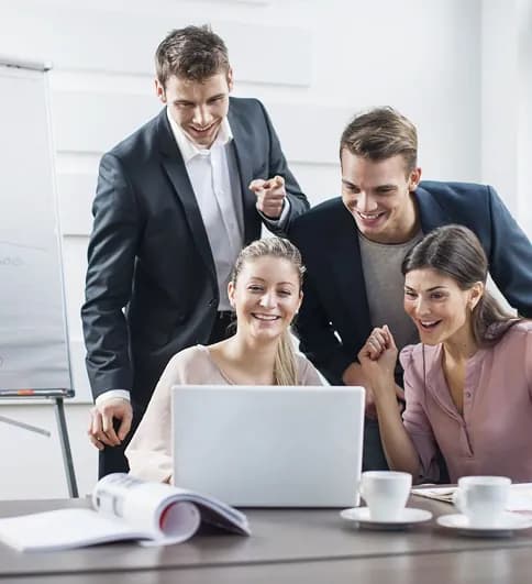 Four colleagues gathered around a laptop