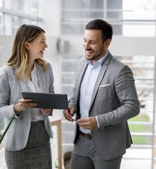 Two colleagues looking at a tablet together in an atrium