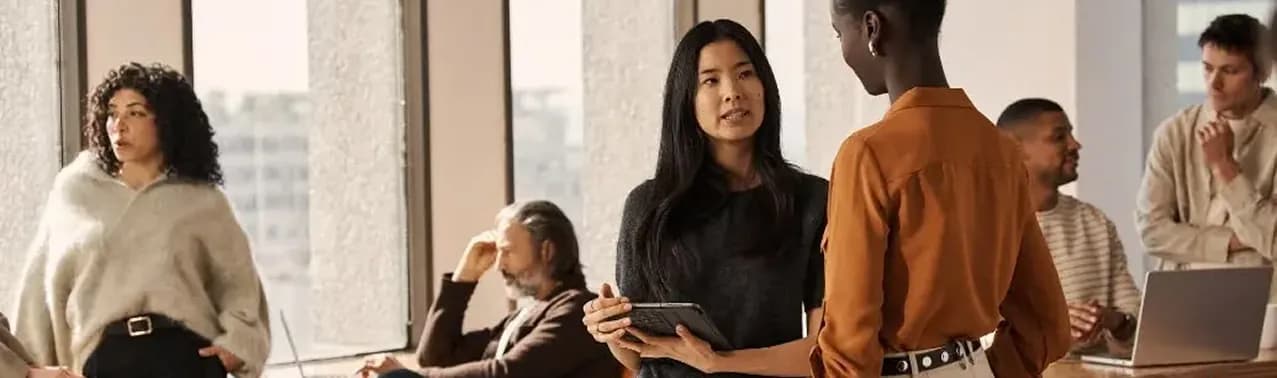 Colleagues talking in a sunlit open-plan office