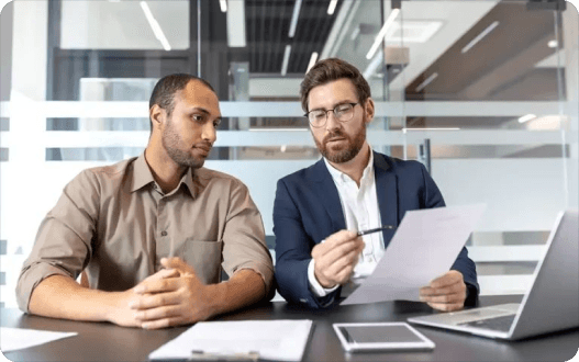 Two professionals in a meeting reviewing document changes together