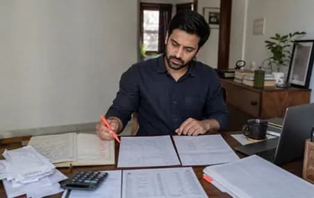Analyst marking up printed reports at a desk