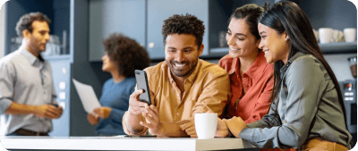 Colleagues collaborating and looking at a mobile phone together in an office