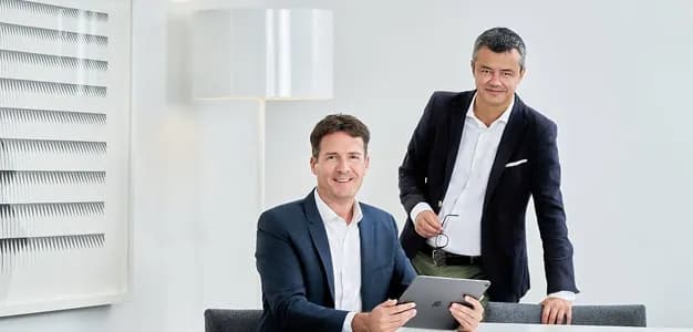 Two colleagues with a tablet in a bright lounge