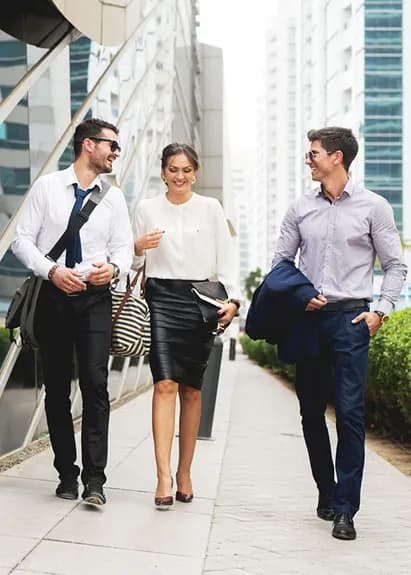 Three colleagues walking and talking on a city street