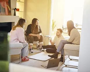 Colleagues talking together in a sunlit lounge